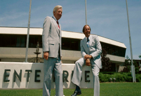Rich DeVos and Jay Van Andel stand outside Amway’s growing business.